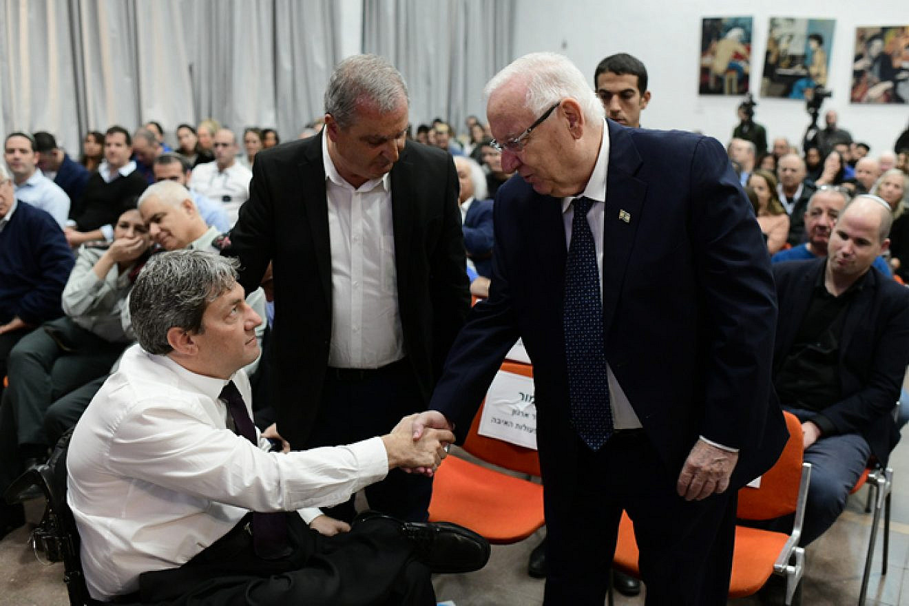 Israeli President Reuven Rivlin shakes hands with Idan Clayman, head of the IDF Organization for the Disabled, at an event in honor of Israeli soldiers disabled in the line of duty, at Beit Halochem in Tel Aviv on Dec. 15, 2019. Photo by Tomer Neuberg/Flash90.