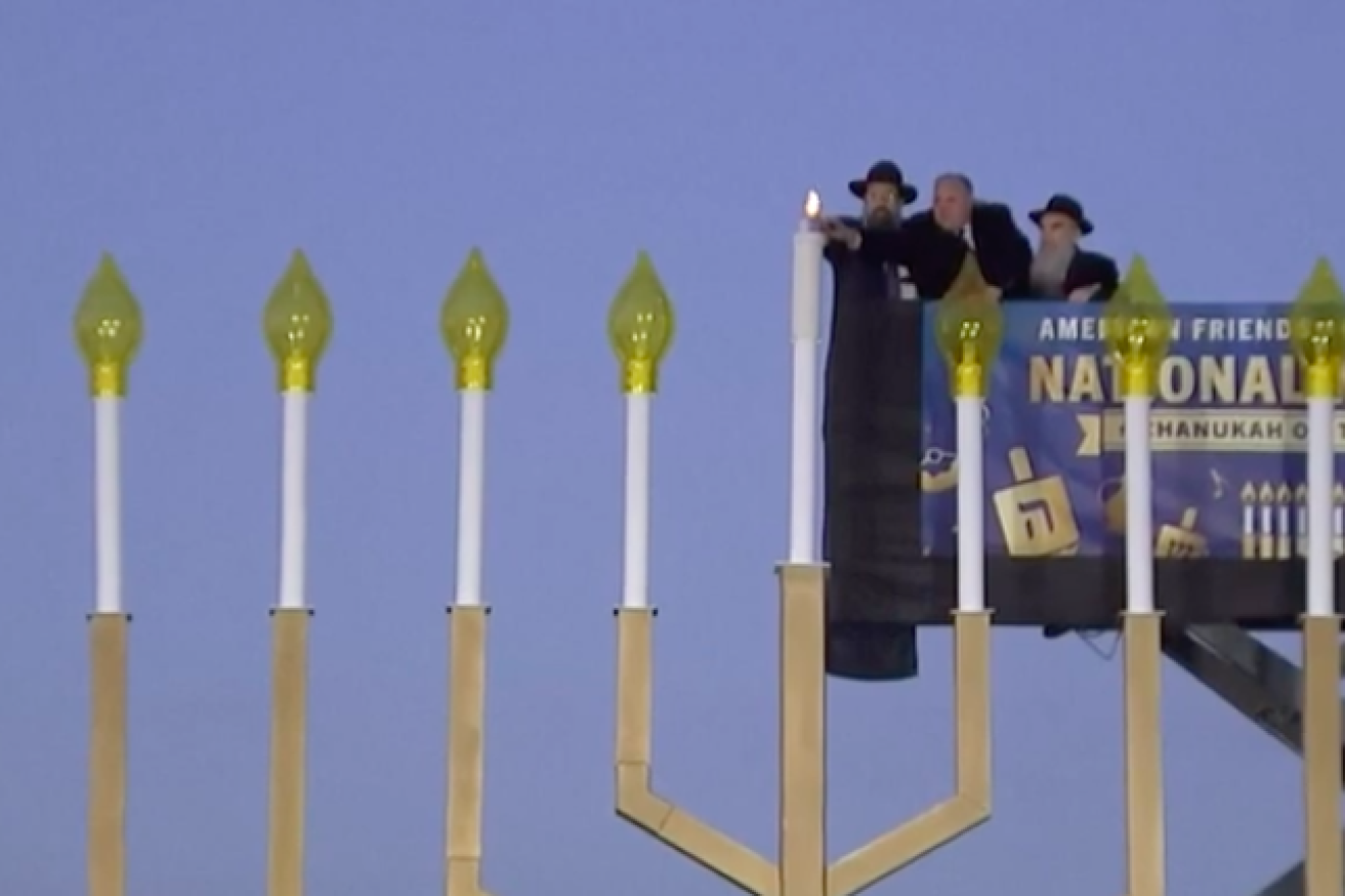 U.S. Interior Secretary David Bernhardt (center) helps light the shamash ("helper candle") of the National Menorah on the Ellipse near the White House in Washington, D.C., on Dec. 22, 2019, assisted by Rabbi Levi Shemtov (left), executive vice president of American Friends of Lubavitch (Chabad), and his father, Abraham Shemtov. Source: Screenshot.