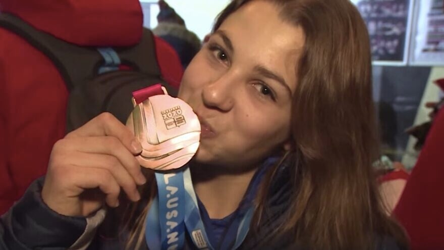 Israeli alpine skier Noa Szollos kissing her gold medal. Source: Screenshot.