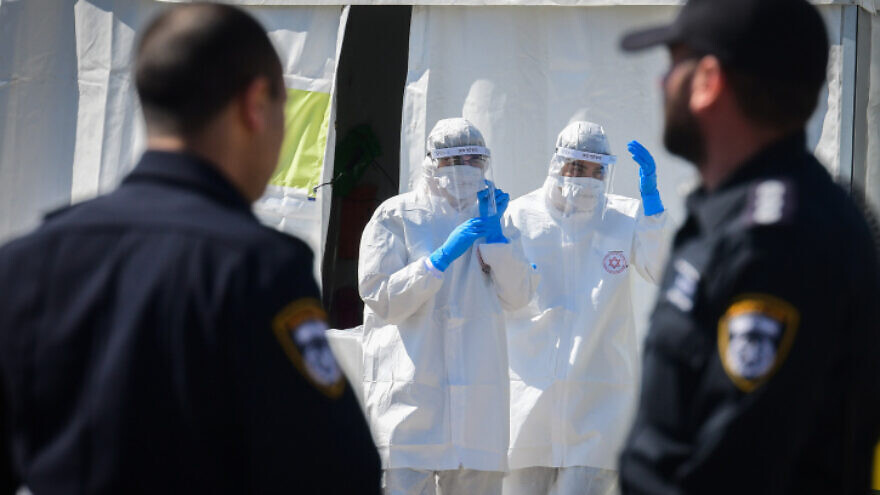 Magen David Adom medical team members in protective gear at a drive-through COVID-19 testing site in Tel Aviv, on March 22, 2020. Photo by Flash90.