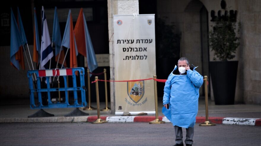 An Israeli worker stands outside the Dan Hotel in Jerusalem that was converted to receive coronavirus patients, March 19, 2020. Photo by Yonatan Sindel/Flash90.