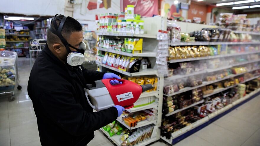 Workers disinfect Bar Kol Supermarket in the northern Israeli city of Tzfat as part of measures to prevent the spread of the coronavirus, March 16, 2020. Photo by David Cohen/Flash90.