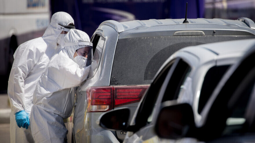 Magen David Adom medical workers test Hebrew Gymnasium high school students and their families at a drive-through coronavirus test site in Jerusalem, on May 30, 2020. Photo by Yonatan Sindel/Flash90.