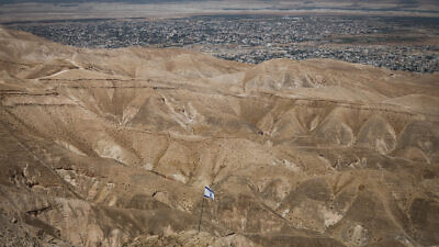 An Israeli flag with a view of the Jordan Valley on June 14, 2020. Photo by Yonatan Sindel/Flash90.