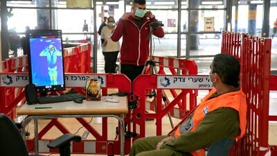 An Israeli officer in the IDF Homefront Command checks the body temperature of visitors with a thermal camera system stationed at Shaare Zedek Medical Center in Jerusalem on April 29, 2020. Photo by Olivier Fitoussi/Flash90.