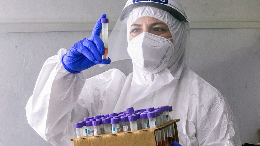 A Maccabi health-fund worker collects COVID-19 test samples in Rehovot on Dec. 15, 2020. Photo by Yossi Aloni/Flash90.
