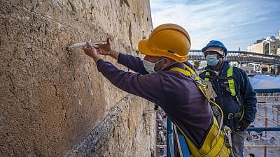 Workers inject liquid grouting into stones of the Western Wall that need strengthening in February of 2021. Credit: Israel Antiquities Authority.
