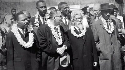 From the documentary film “Spiritual Audacity: The Abraham Joshua Heschel Story,” Rabbi Heschel (second from right) is seen marching with Martin Luther King Jr. and other black civil-rights leaders in Selma, Ala., on March 7, 1965. Source: Screenshot.