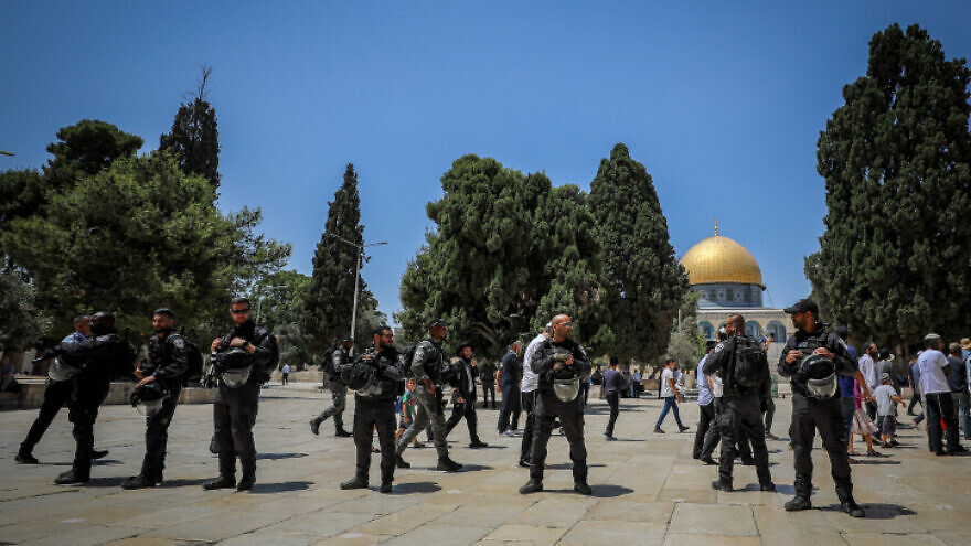 Israeli security forces guard as a group of Jewish visitors on the Temple Mount in Jerusalem's Old City, during Tisha B'Av, July 18, 2021. Photo by Jamal Awad/Flash90