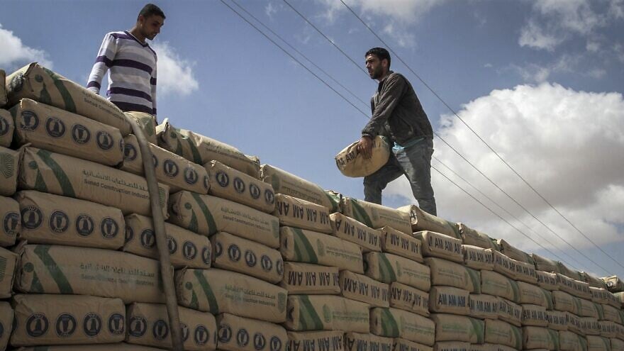 A Palestinian stands on a truck loaded with bags of cement after it entered the southern Gaza Strip from Israel through the Kerem Shalom crossing, May 23, 2016. Photo by Abed Rahim Khatib/Flash90.