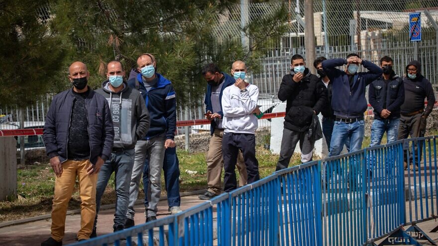 Palestinian laborers with work permits arrive at an Israeli checkpoint to receive a COVID-19 vaccine shot in a temporary medical facility in Jerusalem on March 9, 2021. Photo by Olivier Fitoussi/Flash90.