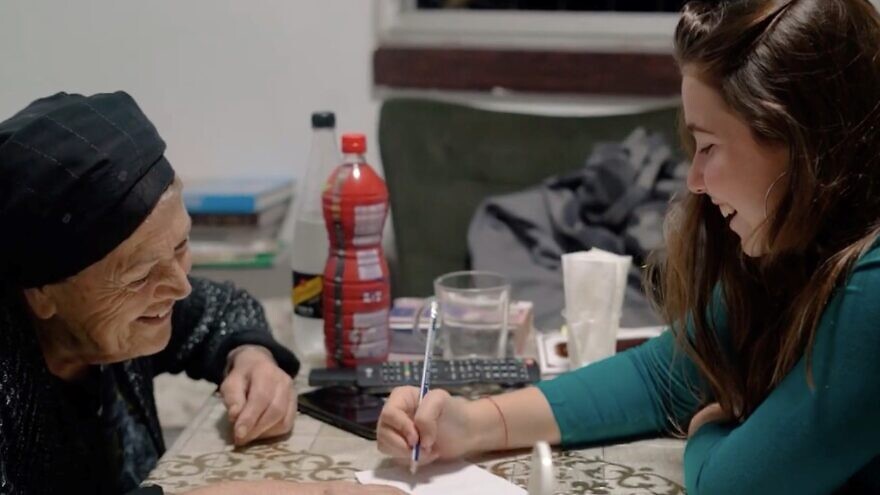 Eliyah Shaked Goldner, a university student volunteer from Ness Ziona, visits a Holocaust survivor as part of the “Get Chesed” program overseen by Colel Chabad. Credit: Courtesy.