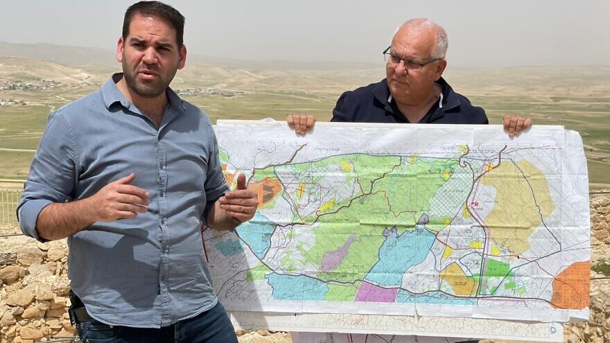 Yishai Merling, head of the World Zionist Organization's Settlement Division (left), with Settlement Division Architect Yoel Rivlin displaying a map showing the section of the Negev where Highway 25 and Highway 31 are located. Credit: Courtesy.