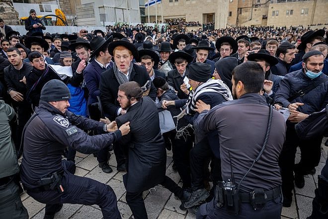 Haredi Jews scuffle with police as they protest members of the Women of the Wall movement bringing in Torah scrolls to their hold Rosh Chodesh prayers at the Western Wall in Jerusalem Old City, March 4, 2022. Photo by Yonatan Sindel/Flash90.