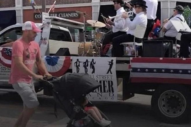 A father rushes his child to safety as gunshots are fired at a Fourth of July parade in Highland Park, Ill., on July 4, 2022. Credit: @LynnSweet/Chabad.org News.