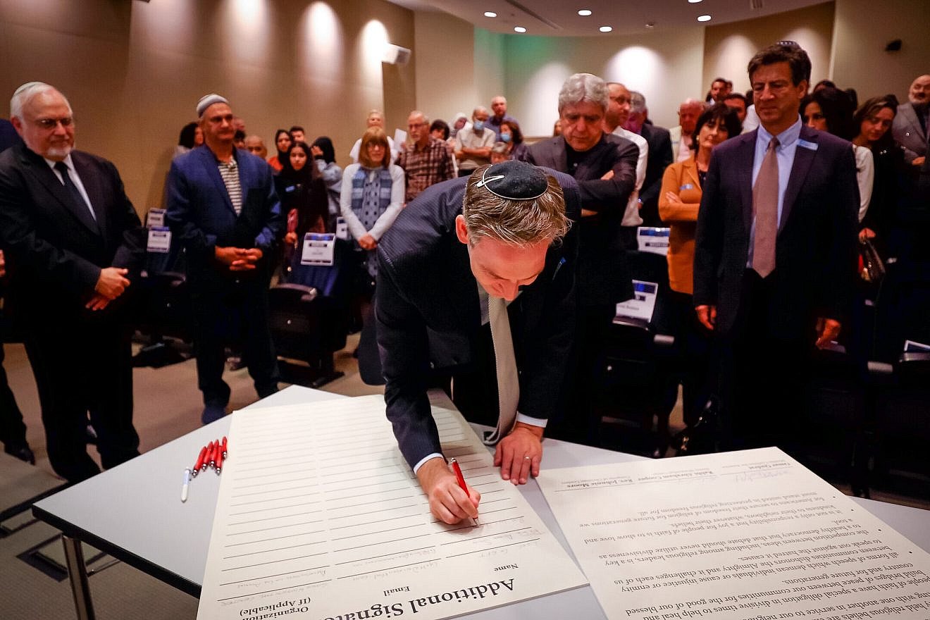 Rabbi Erez Sherman of Sinai Temple in Los Angeles signs the United States Multifaith Unity Statement. CreditL Courtesy.