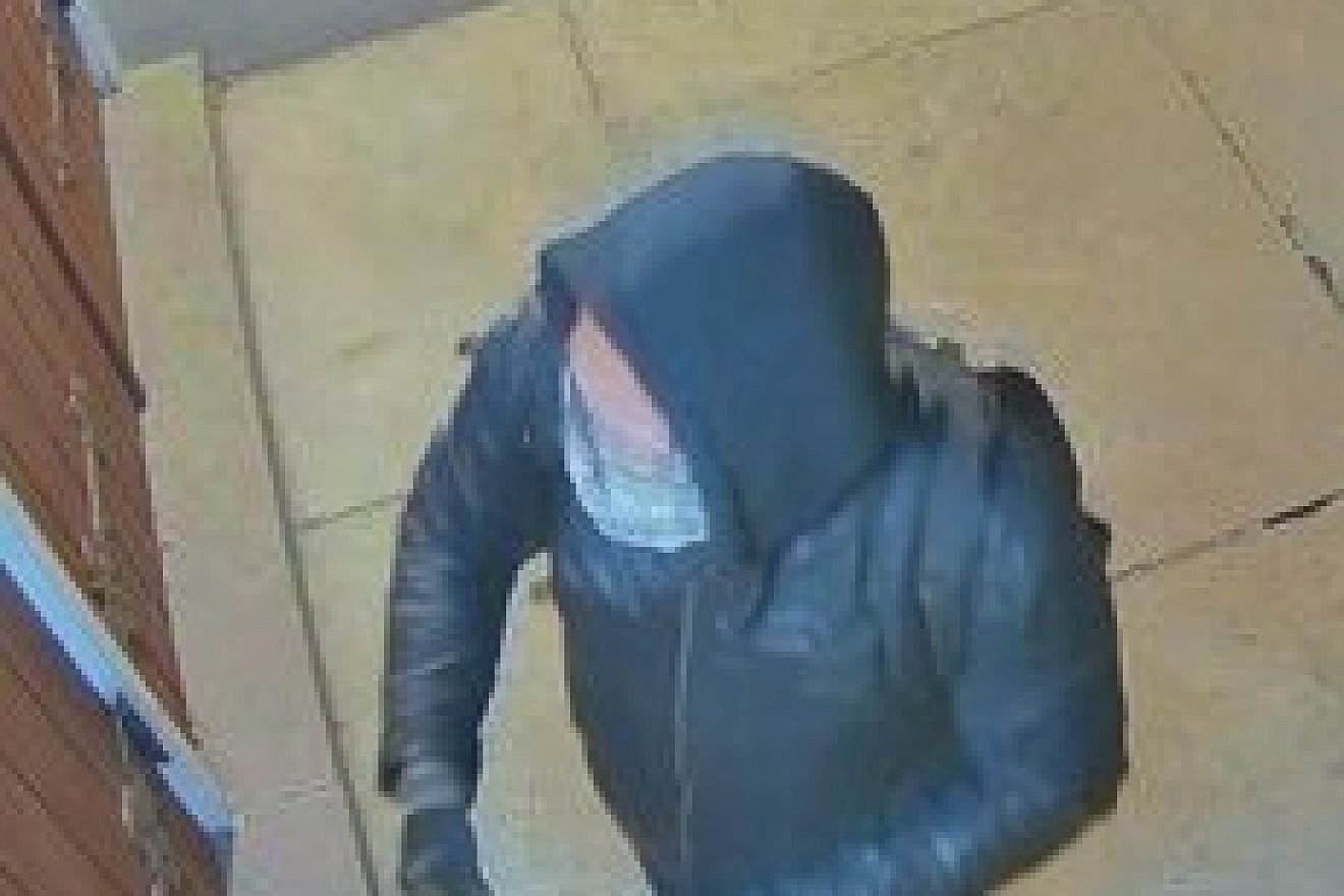 Surveillance video shows a man placing stickers, including some with an image of Adolf Hitler, on the Beth Isaiah Synagogue in Guelph, Ontario, Oct. 5, 2022. Credit: Guelph Police Service.