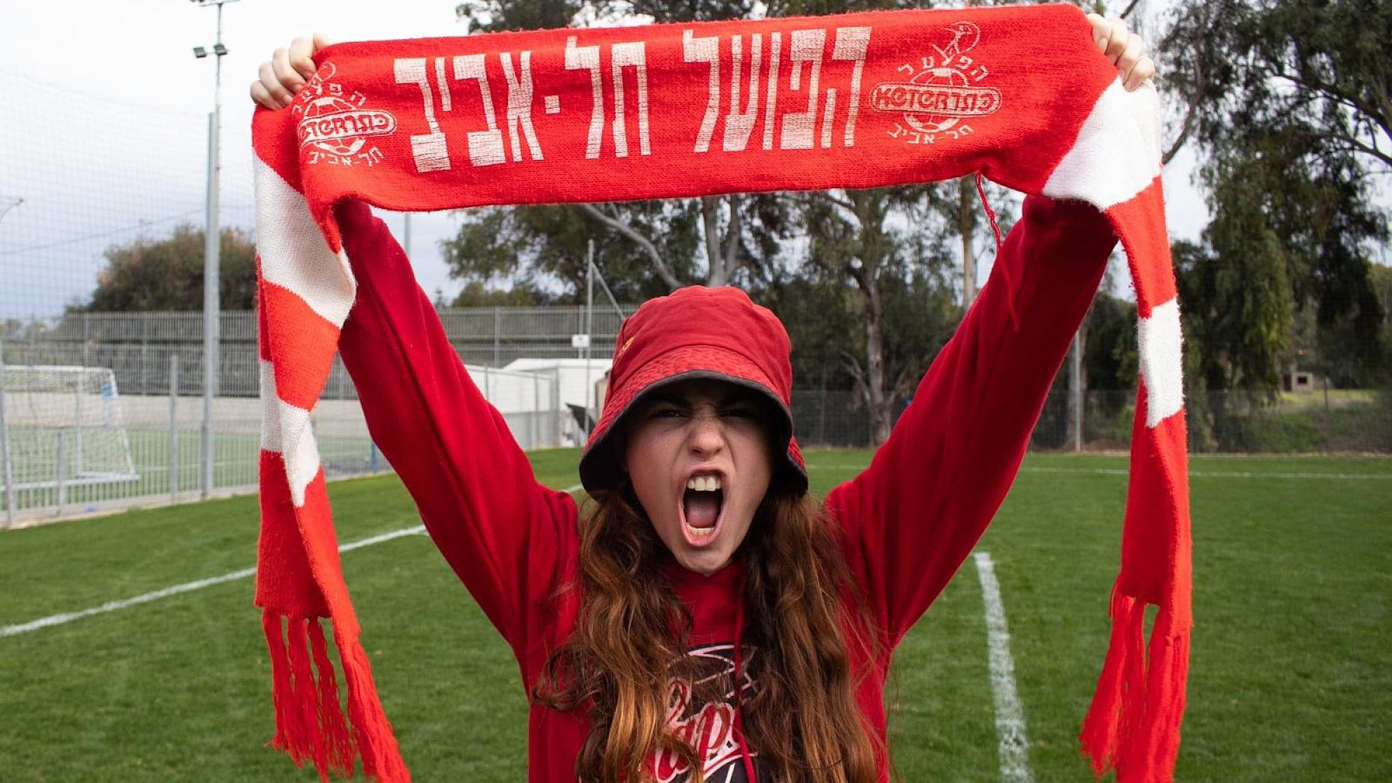Superfan Amit Kaminsky holds aloft the colors of Hapoel Tel Aviv F.C. Credit: Courtesy.