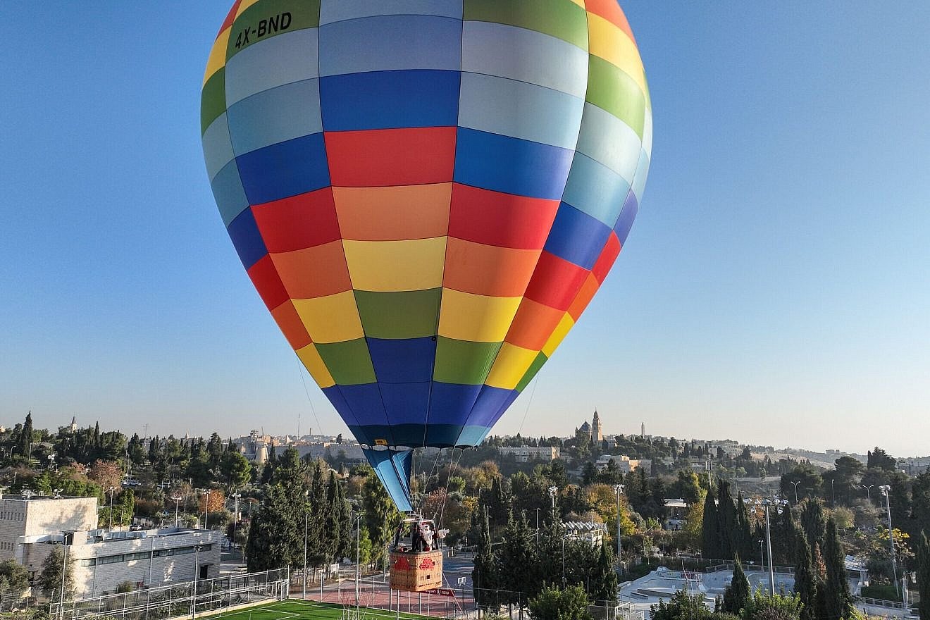 Jerusalem Santa Issa Kassissieh extends 2022 Christmas greetings to Christians worldwide from a hot air balloon flying over the Old City. Credit: Shmuel Cohen.