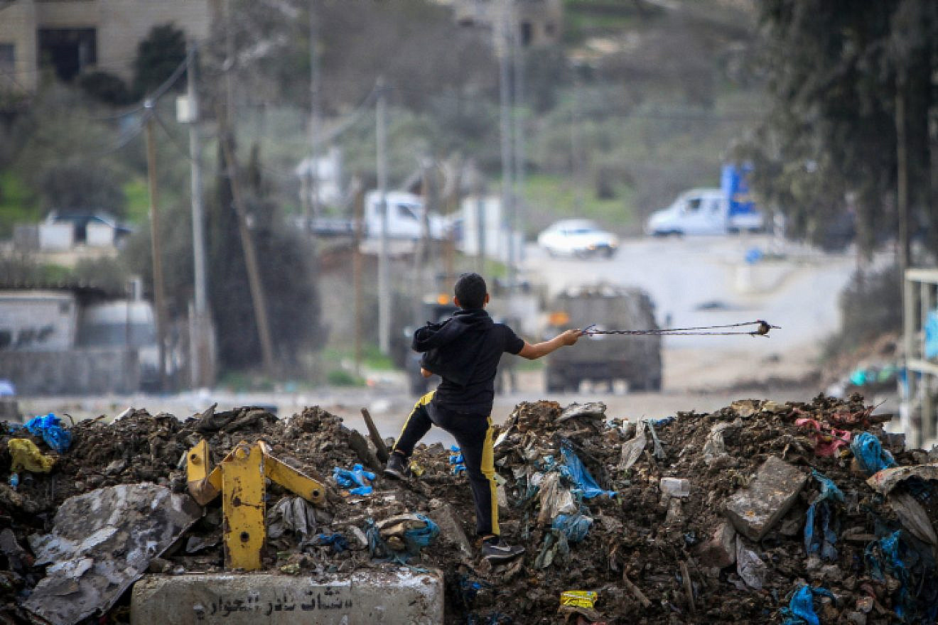 A Palestinian boy readies to throw a stone at Israeli security forces during a protest in the village of Beita, near the city of Nablus, Jan. 28, 2023. Credit: Nasser Ishtayeh/Flash90.