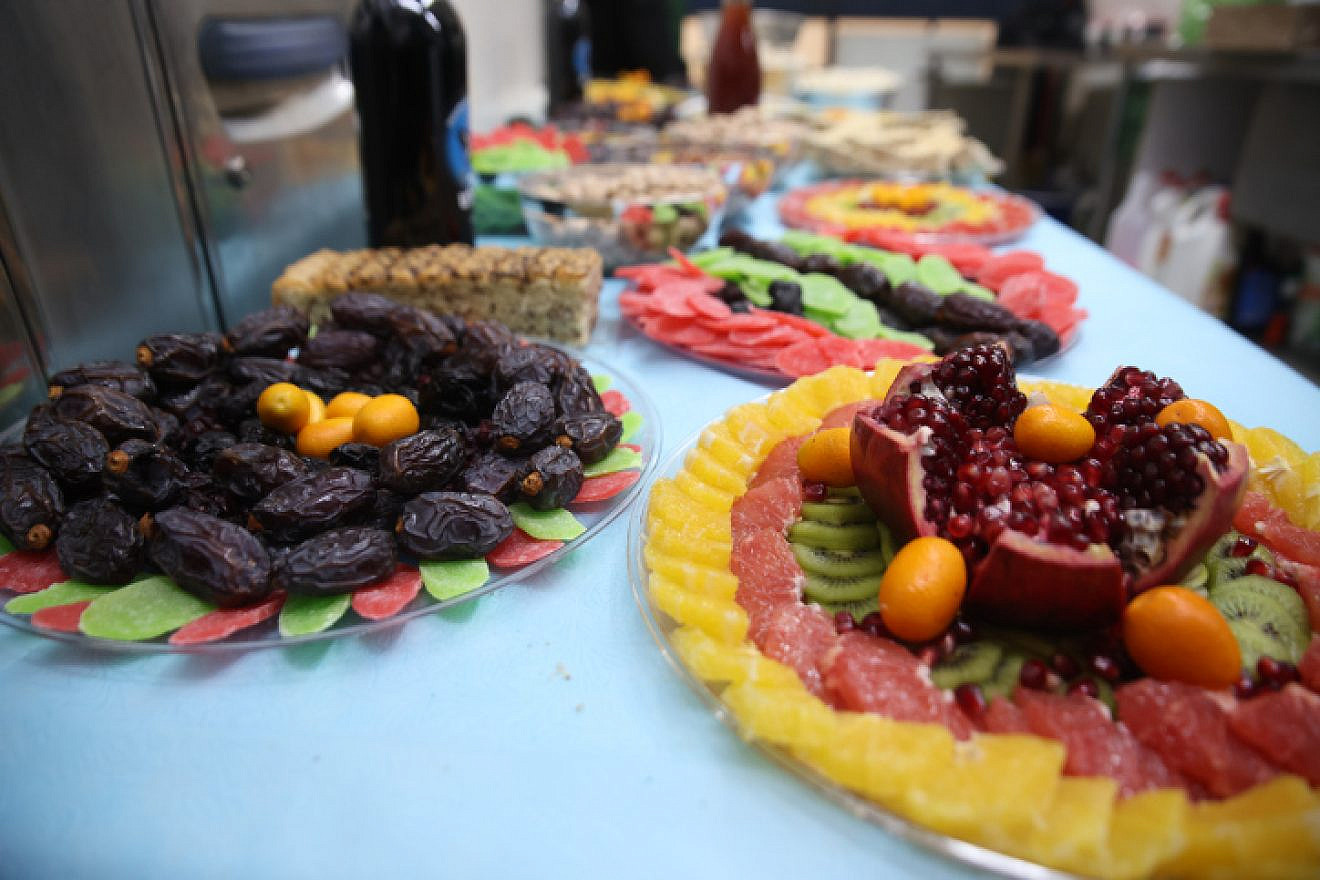 A table full of fruits and nuts, traditionally eaten for the Tu B'Shevat holiday, at the Rashbi's gravesite in Meron, Jan. 16, 2022. Photo by David Cohen/Flash90.