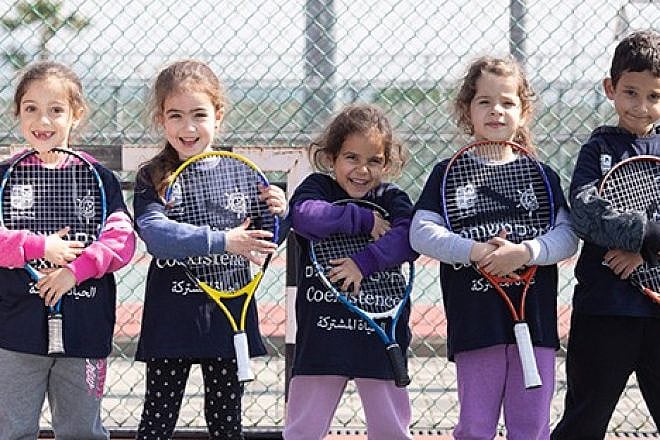Players from the Israel Tennis & Education Centers wear coexistence-themed shirts. Credit: Israel Tennis & Education Centers.