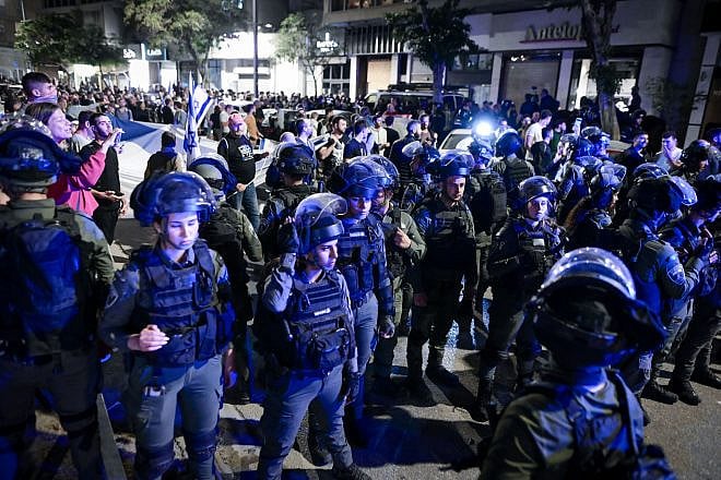 Police officers stand guard while Israelis demonstrate against Prime Minister Benjamin Netanyahu's wife Sara Netanyahu, outside a hair salon in Tel Aviv on March 1, 2023. Photo: Avshalom Sassoni/Flash90