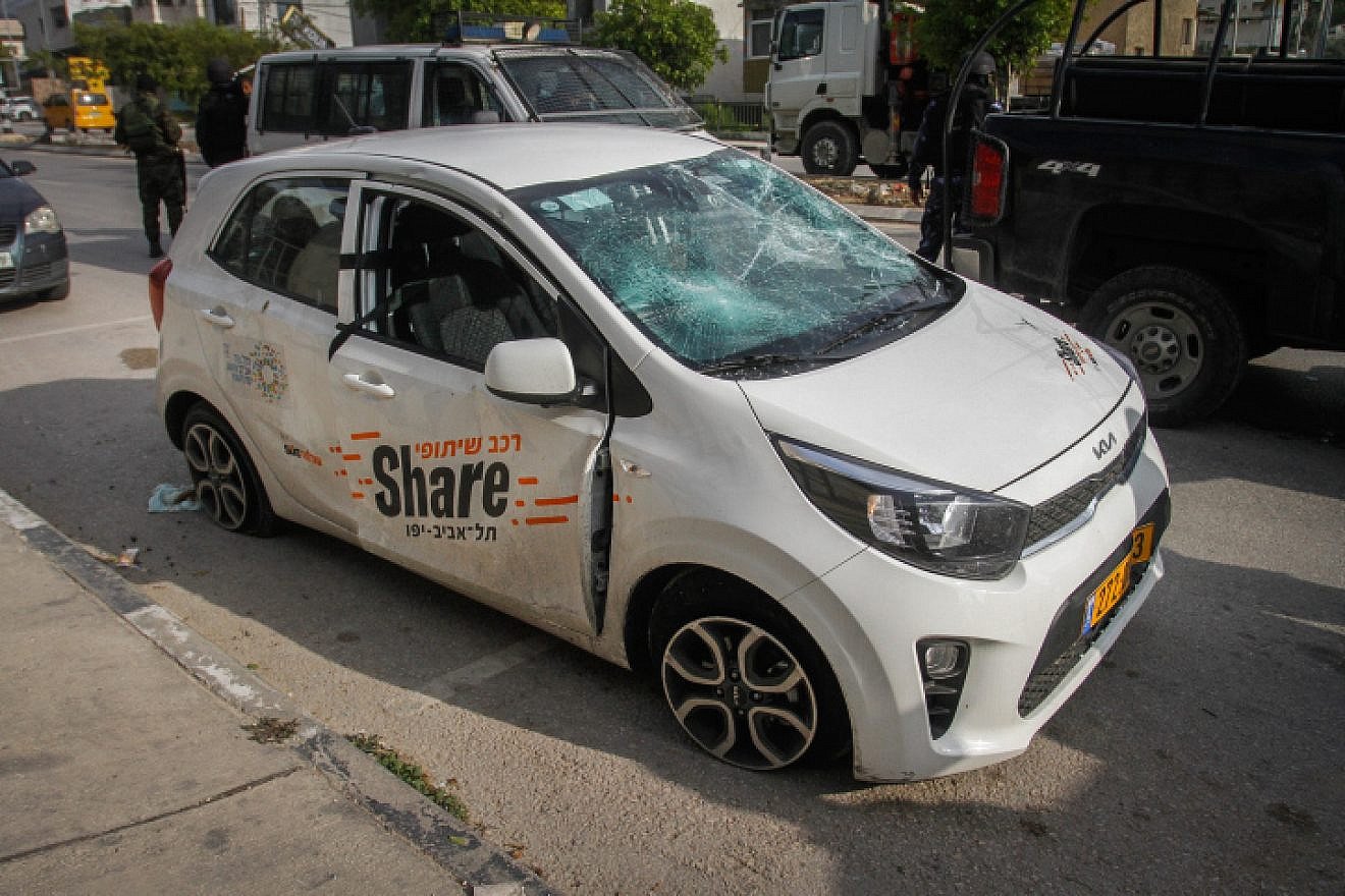 Palestinian police stand next to an Israeli sharing car driven by German tourists, attacked by Palestinian youth in Shechem (Nablus) in northern Samaria on March 18, 2023. Photo by Nasser Ishtayeh/Flash90.