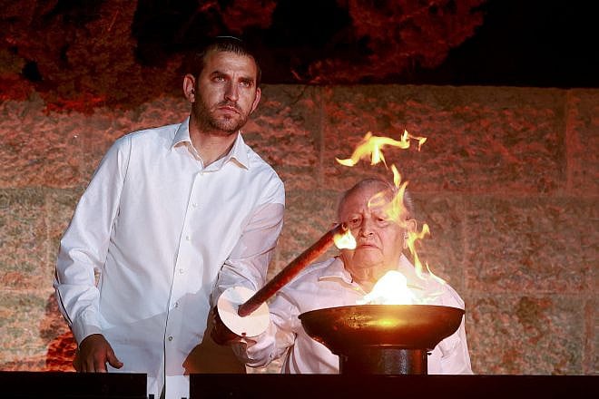 Holocaust survivor Ben-Zion Raisch and a family member light a torch during a ceremony at the Yad Vashem Holocaust Memorial Museum in Jerusalem, as Israel marks Holocaust Remembrance Day on April 17, 2023. Photo by Erik Marmor/Flash90.