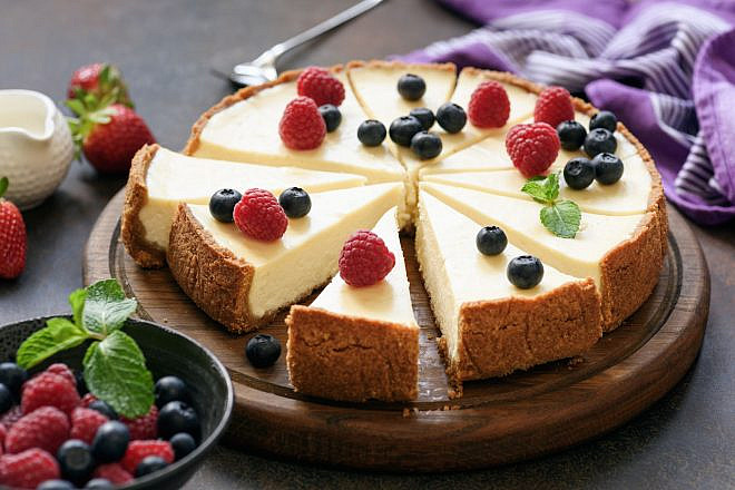 Classic plain New York Cheesecake sliced on wooden board. Photo: Vladislav Noseek/Shutterstock