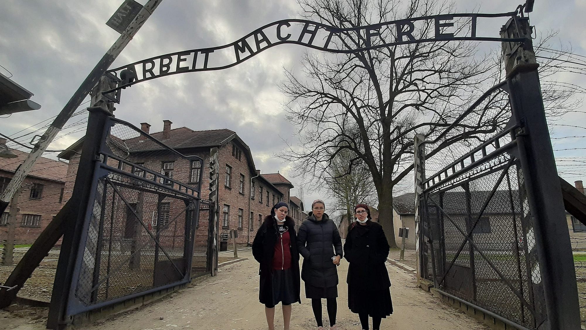 At the entrance to Auschwitz: "Triumph of the Spirit" director Miriam Cohen is flanked by producers Chani Kopilowitz (left) and Yuti Neiman. Credit: Courtesy of Triumph of the Spirit.