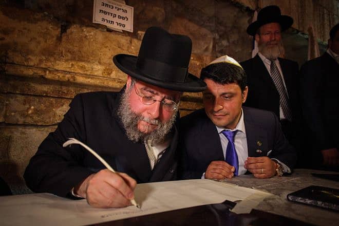 Rabbi Pinchas Goldschmidt helps to write a new Torah scroll in the Western Wall tunnels in Jerusalem, May 21, 2014. Photo by Flash90.