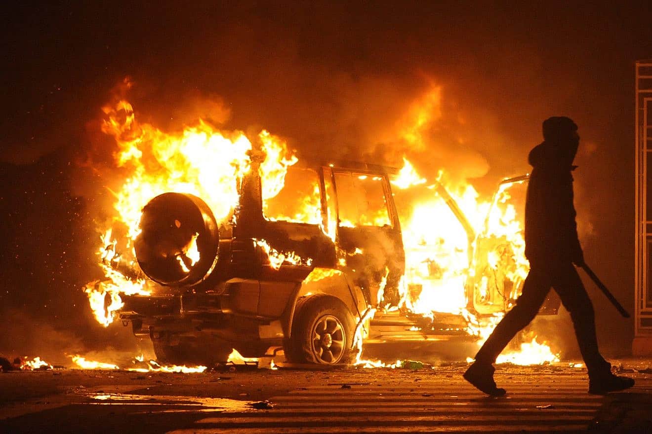 A burning car during riots in Paris, France. Credit: Bumble Dee/Shutterstock.