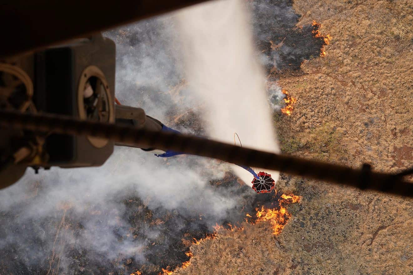 Two Hawaii Army National Guard CH47 Chinooks perform aerial water-bucket drops on the island of Maui to assist in fighting the wildfires, Aug. 9, 2023. Credit: U.S. National Guard Video by Air Force Master Sgt. Andrew Jackson.