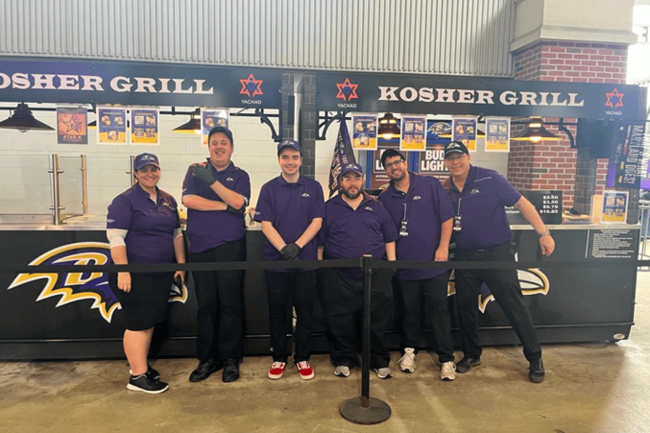 From left: At Yachad’s Kosher Grill: Yachad Baltimore City Director Sima Levine; Yachad participants Yitzi Lencz and Yosef Katz; Star-K Mashgiach Moshe Levi; Kosher Stand Manager Adam Baruch; and Yachad parent Barry Nabozny, who conceived of the initiative.