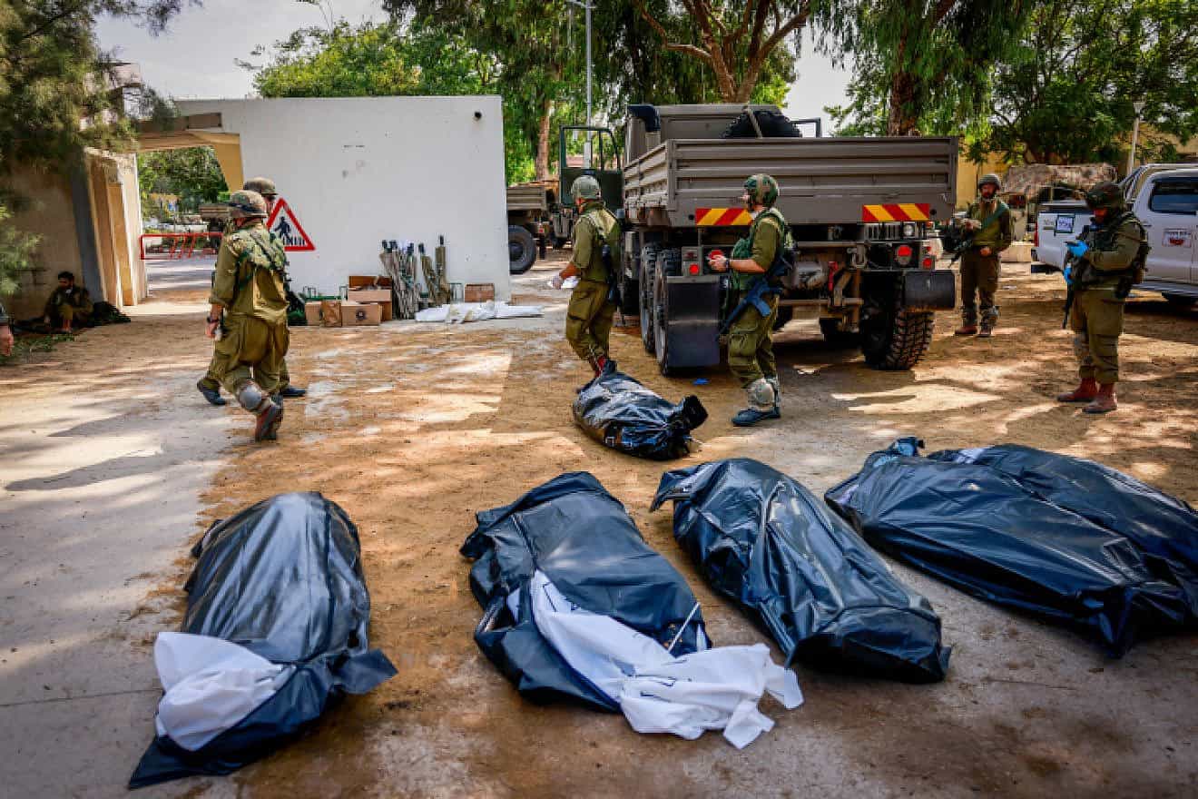 IDF soldiers remove the corpses of civilians in Kibbutz Kfar Aza, near the Gaza Strip, Oct. 10, 2023. Photo by Chaim Goldberg/Flash90.