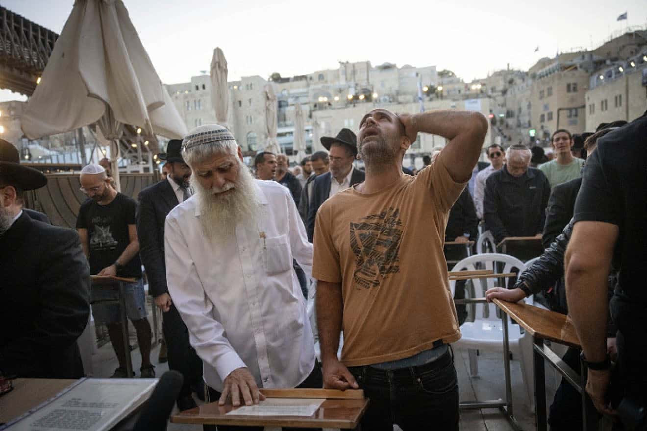 Avichai Brodtz, whose wife and three children were abducted by Hamas, and Shmuel Rabinowitz, the rabbi of the Western Wall, pray for the release of people held hostage, at the Western Wall in Jerusalem, October 19, 2023. Photo by Chaim Goldberg/Flash90.