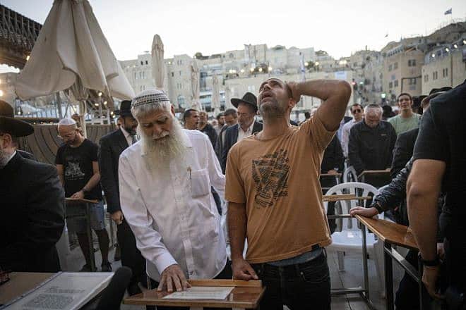 Avichai Brodtz, whose wife and three children were abducted by Hamas, and Shmuel Rabinowitz, the rabbi of the Western Wall, pray for the release of people held hostage, at the Western Wall in Jerusalem, October 19, 2023. Photo by Chaim Goldberg/Flash90.