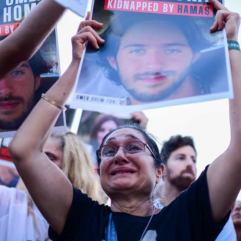 Families of Israelis held hostage by Hamas terrorists in the Gaza Strip hold up photographs outside of the Tel Aviv Museum of Art on Oct. 26, 2023. Photo by Tomer Neuberg/Flash90.