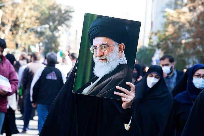 A veiled woman holds a photo of Iran's Supreme Leader Ayatollah Ali Khamenei, Nov. 4, 2022. Credit: saeediex/Shutterstock.