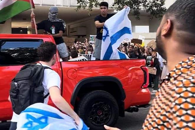 Anti-Israel protesters start to burn an Israeli flag during a rally at Tulane University in New Orleans, Oct. 26, 2023. Photo by Pnina Sasson.