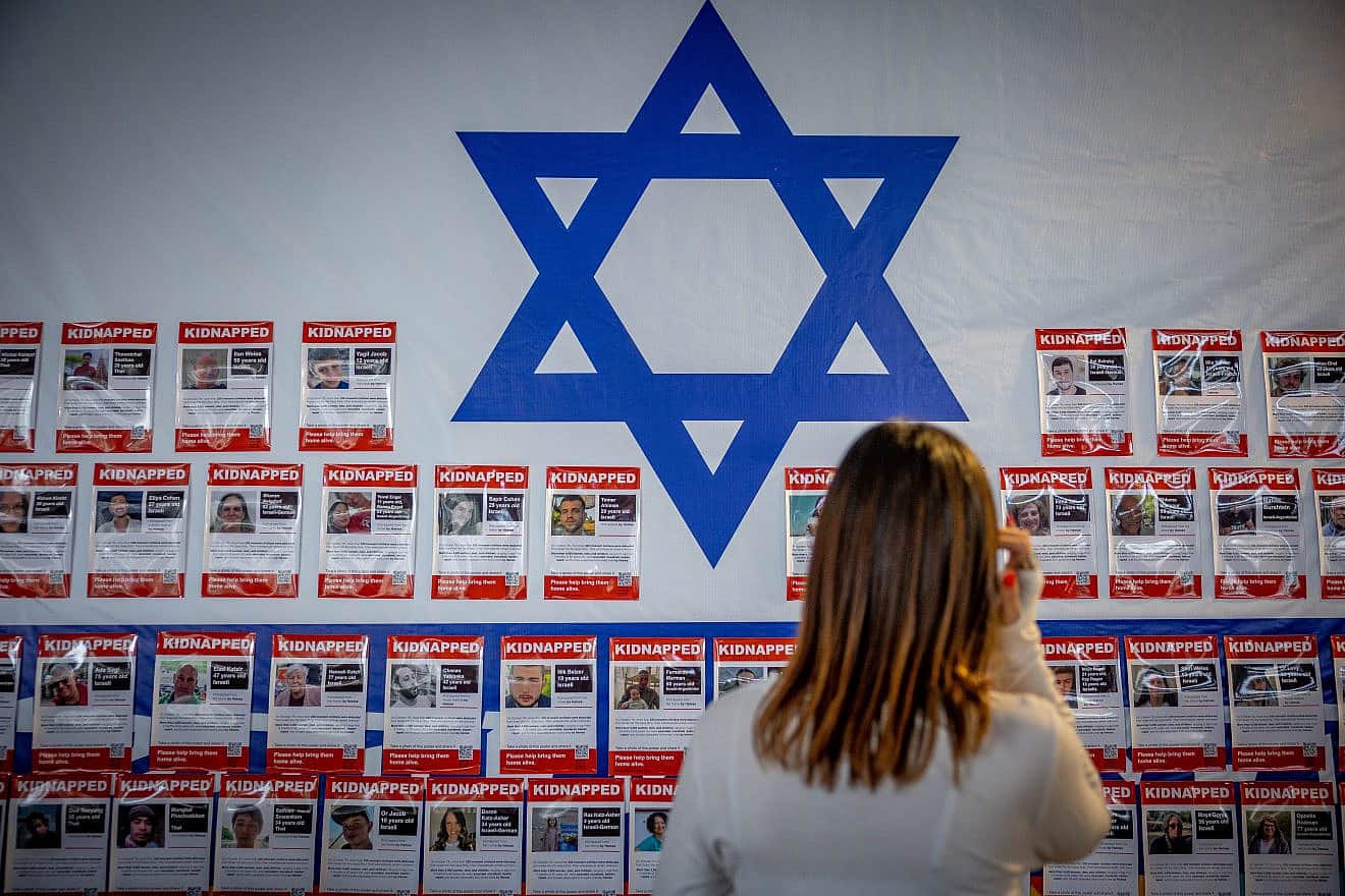 People in Jerusalem walk next to pictures of civilians held hostage by Hamas terrorists in the Gaza Strip, Nov. 22, 2023. Photo by Yonatan Sindel/Flash90.