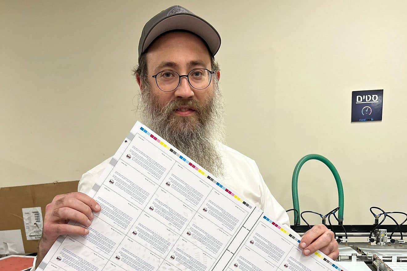 Rabbi Menachem Traxler of Colel Chabad with debit cards printed in Kibbutz Be'eri for displaced Israelis to use for basic needs following the terrorist attacks of Oct. 7, 2023. Credit: Courtesy,