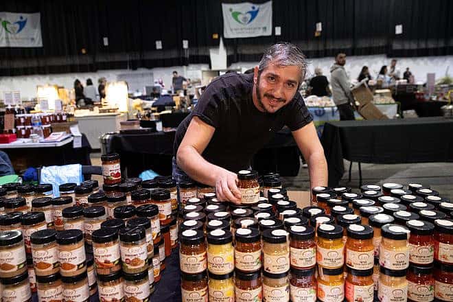 A business owner at the Hangar 11 Fair at the Tel Aviv Port, December 2023. Photo by Yoav Lin.