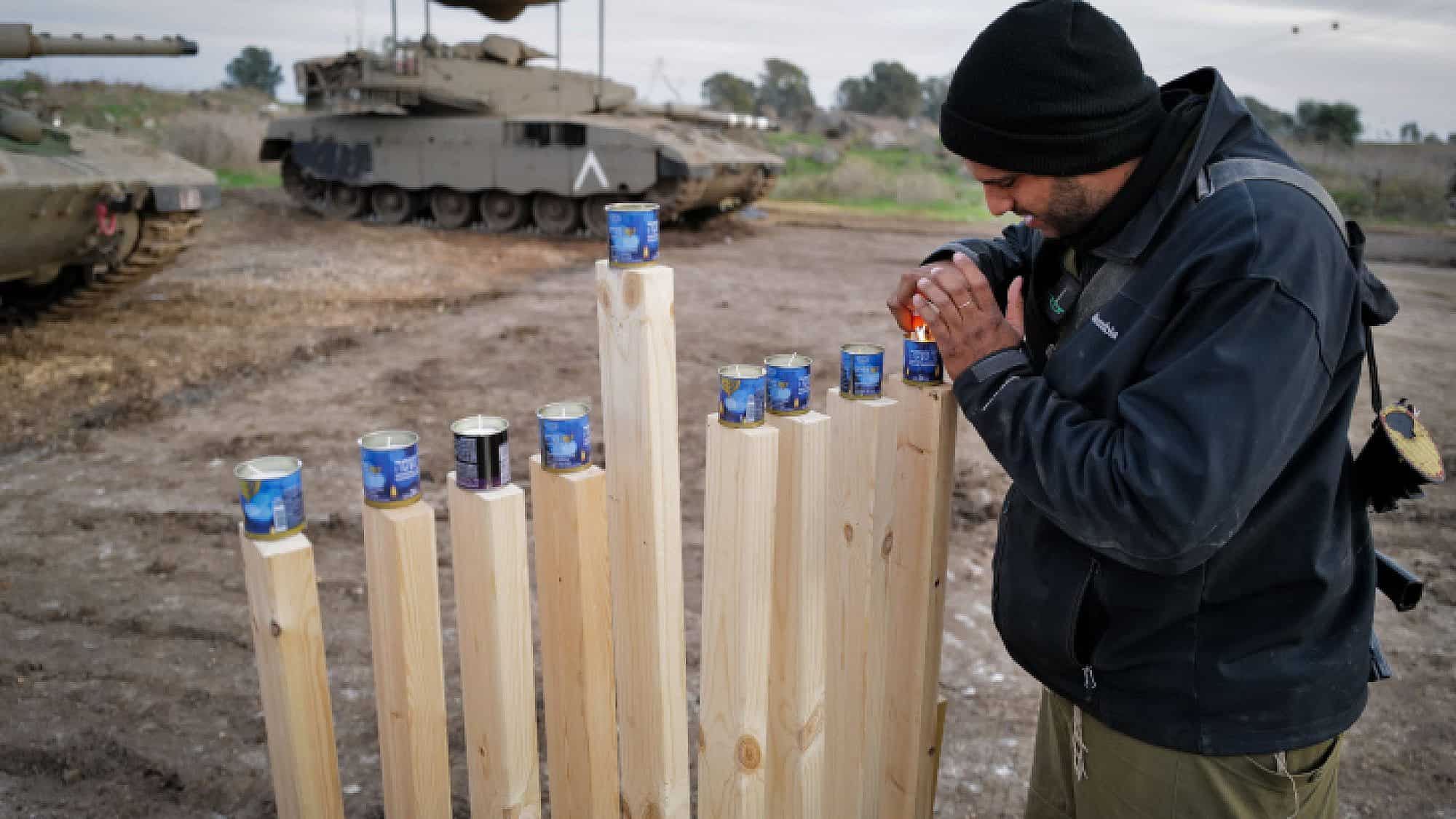 Israeli soldiers light candles on the second night of Chanukah, at a staging area near the Israeli border with Syria, on Dec. 8, 2023. Photo by Michael Giladi/Flash90.
