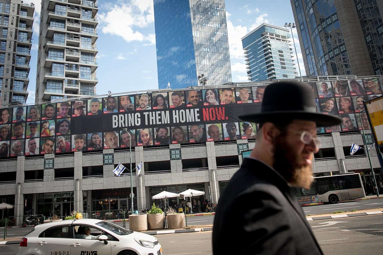 People walk by photographs of civilians who have been held or are still held hostage by Hamas terrorists in Gaza, in Ramat Gan. Jan. 21, 2024. Photo by Miriam Alster/Flash90.
