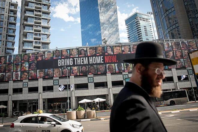 People walk by photographs of civilians who have been held or are still held hostage by Hamas terrorists in Gaza, in Ramat Gan. Jan. 21, 2024. Photo by Miriam Alster/Flash90.