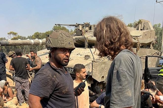Daniel Sharabi (wearing helmet) and other Israelis regroup and treat the wounded after fleeing Hamas's attack on the Supernova Music Festival at Kibbutz Re'im on Oct. 7, 2023. Credit: Courtesy.