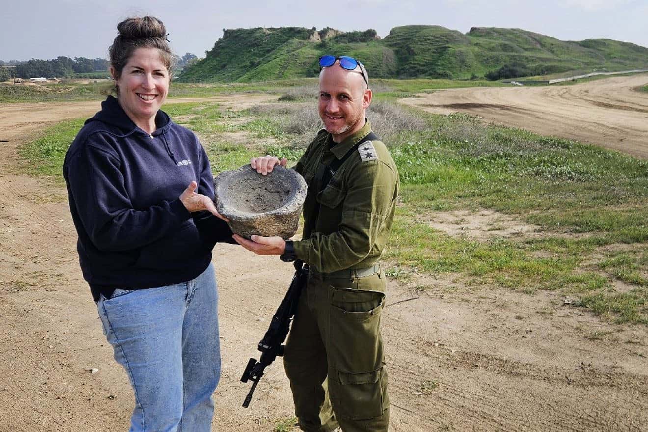 Archaeologist Sarah Tal from the Israel Antiquities Authority and Lt. Col. Yair Amitsur with the grinding mortar. Photo by Ilon Glick.