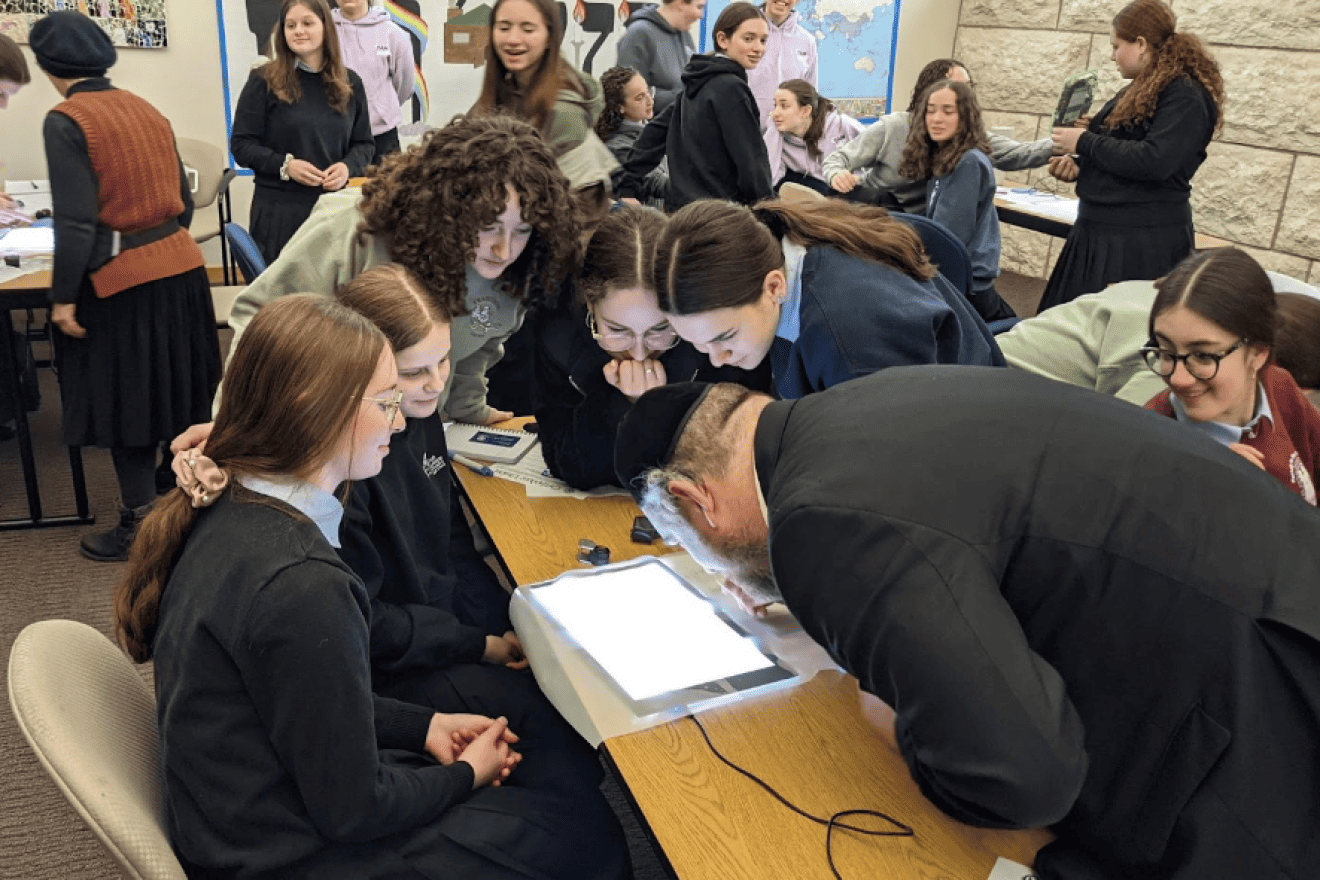 OU Kosher Rabbinic Coordinator Rabbi Daniel Sharrat demonstrates the process of bedikas tolayim (checking for insect infestation) at Torah Academy of Milwaukee (TAM). Credit: Courtesy.